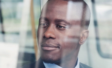 Man looking out window thinking of Prudential Regulation Authority priorities for 2025