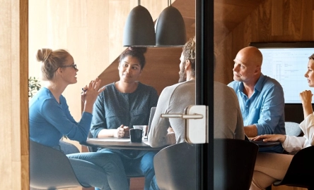 People sat round a boardroom table in discussion